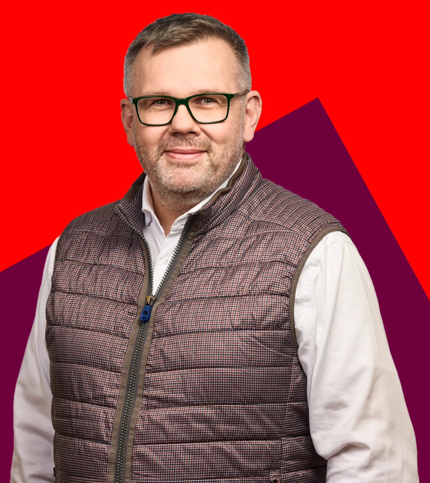 René Schernikau, mann in Hemd und Weste vor rotem Hintergrund